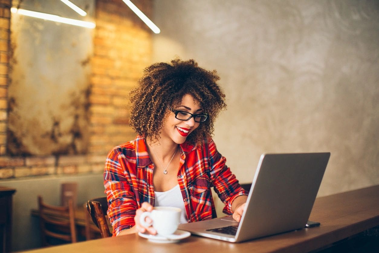 A woman sitting at a table with a laptop.